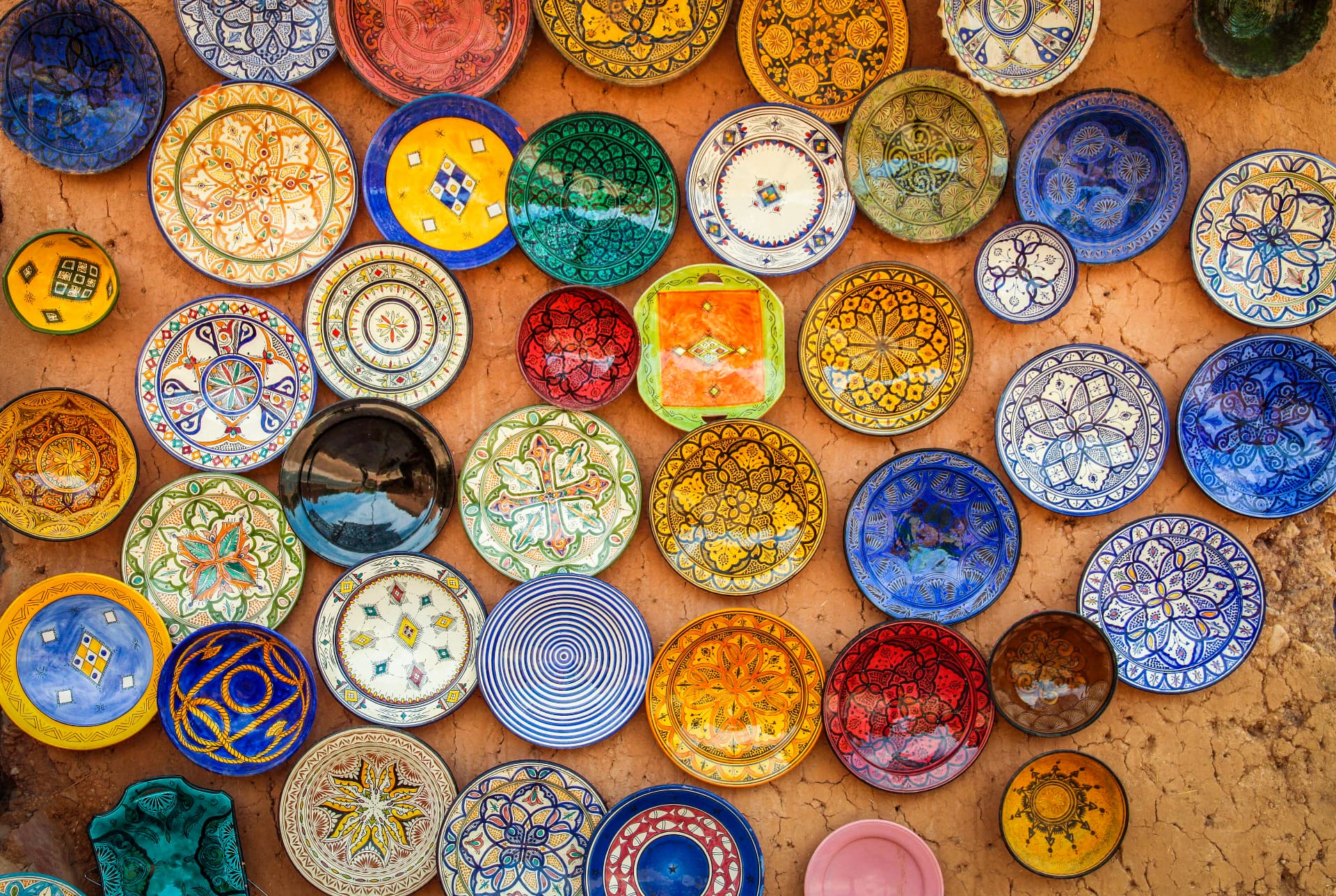 Hand-painted Moroccan pottery plates displayed on a clay wall