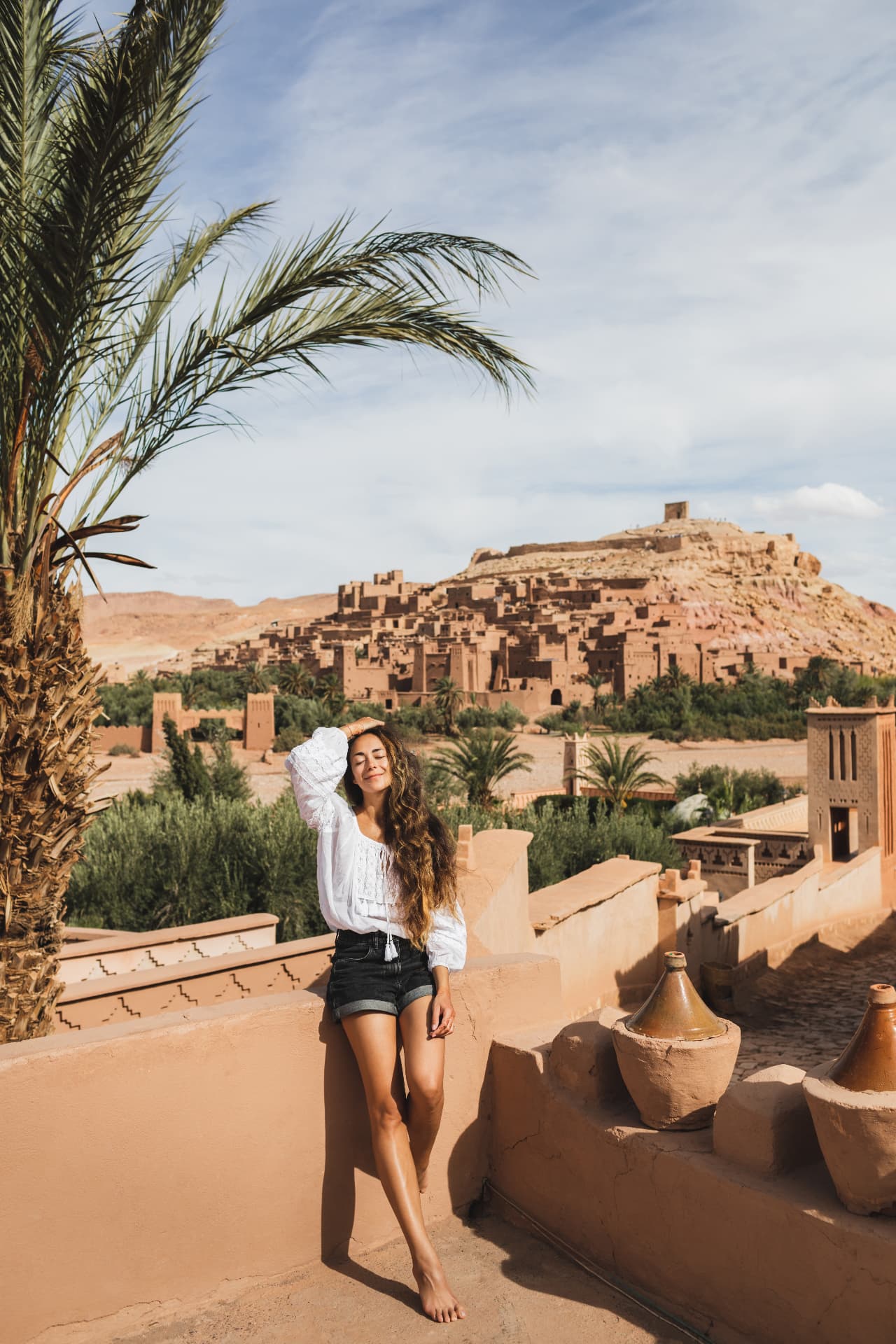Woman smiling on a rooftop terrace overlooking Aït Benhaddou