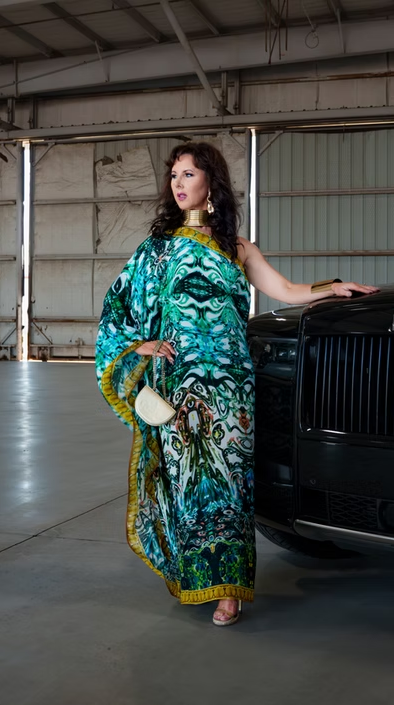 Woman in a printed kaftan beside a luxury car