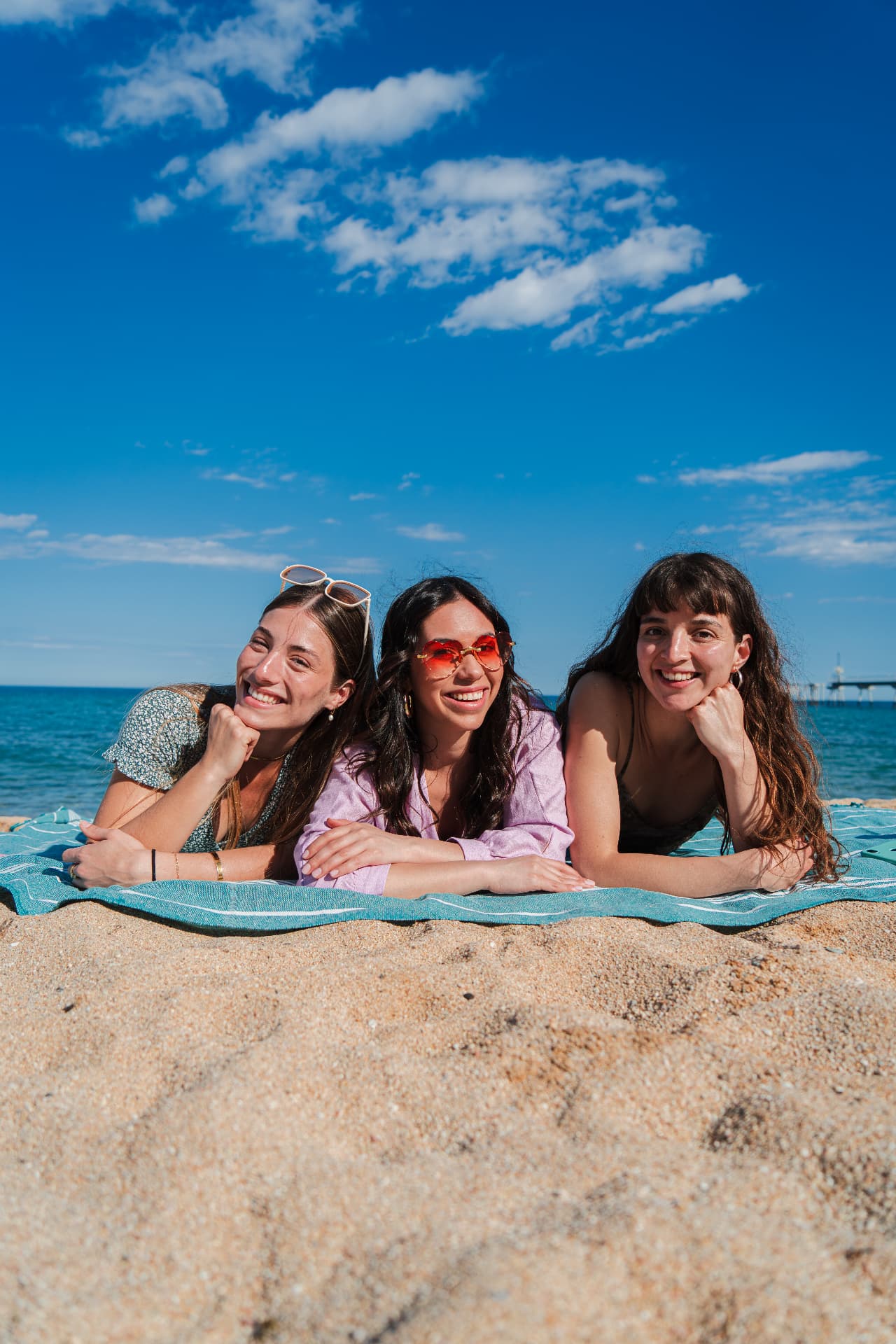 Friends lying on the sand at the beach