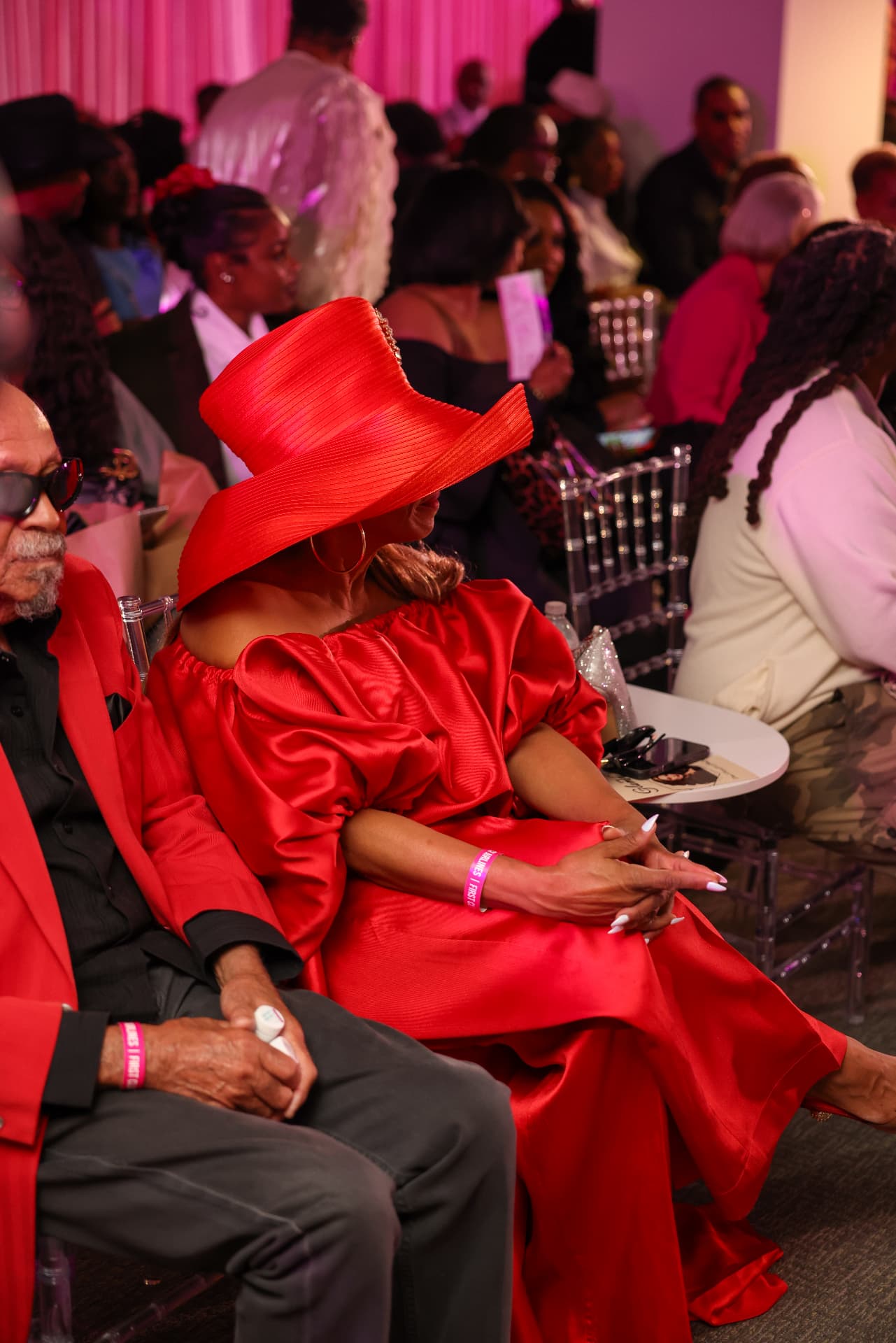 Guest in a red hat and gown at the Girls Trip Society event